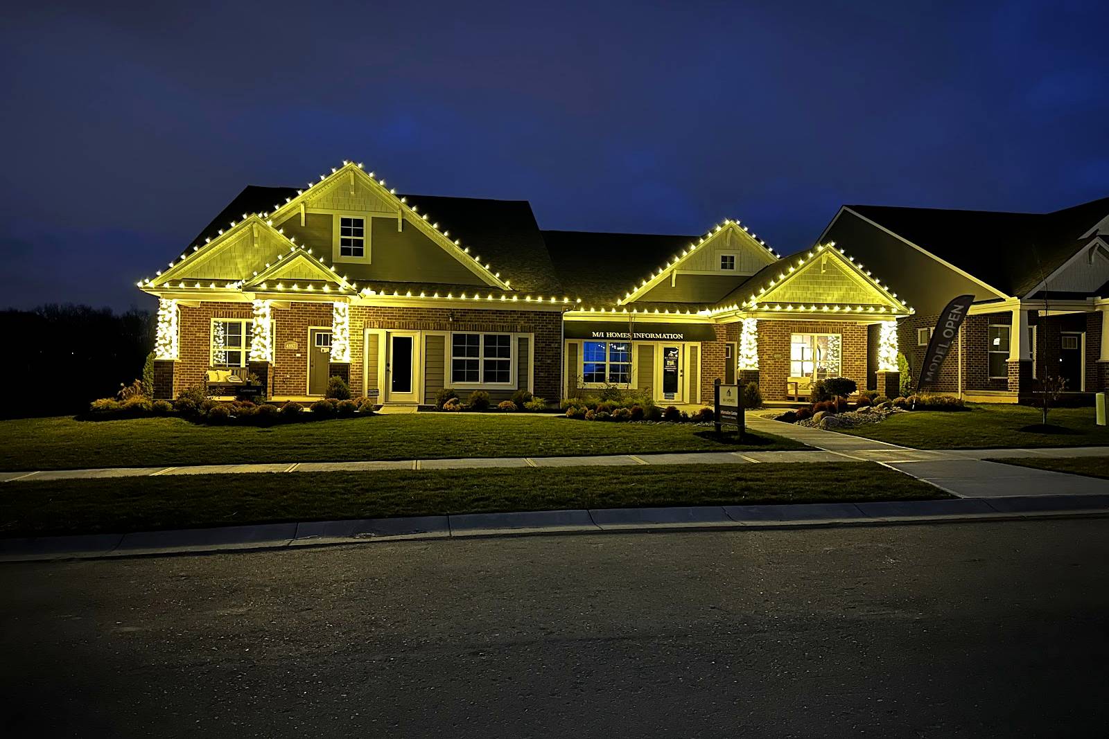 Craftsman style home with warm white Christmas lights along the roofline and gables at dusk, installed by Liberty Christmas Lights