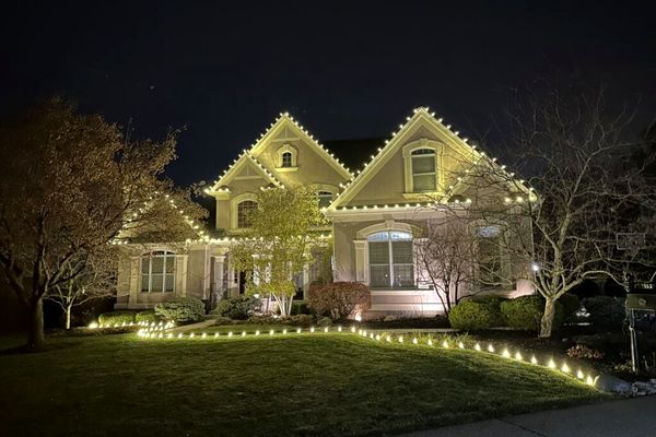 Warm white roofline Christmas lights with lighted walkway and lawn stakes in Indian Hill, OH